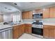 Well-equipped kitchen with stainless steel appliances, wood cabinetry, and adjacent breakfast bar at 9100 Balcony Trellis Ave, Las Vegas, NV 89149