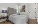 Cozy bedroom features a plush bed with a gray, velvet headboard and wood-look floors at 940 Viscanio Pl, Las Vegas, NV 89138