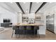 Modern kitchen featuring a large island with seating, stainless steel appliances, and stylish wooden beam accents at 940 Viscanio Pl, Las Vegas, NV 89138