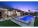 A backyard pool and spa feature led lighting and outdoor lounge area under the darkening sky at 940 Viscanio Pl, Las Vegas, NV 89138