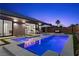 A backyard pool and spa feature led lighting and outdoor lounge area under the darkening sky at 940 Viscanio Pl, Las Vegas, NV 89138
