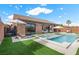 Backyard pool with tanning ledge, patio and artificial turf, with indoor/outdoor living space at 940 Viscanio Pl, Las Vegas, NV 89138