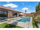 Backyard pool with tanning ledge, patio and artificial turf, and indoor/outdoor living space at 940 Viscanio Pl, Las Vegas, NV 89138