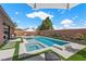 Inviting backyard pool and spa with artificial turf, lounge seating, and clear blue skies at 940 Viscanio Pl, Las Vegas, NV 89138