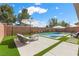 Backyard pool with tanning ledge, patio and artificial turf, with lounge seating and shade umbrellas at 940 Viscanio Pl, Las Vegas, NV 89138