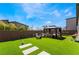 Spacious backyard with a gazebo, outdoor seating, and lush artificial turf, perfect for entertaining at 9565 Camelback Creek Dr, Las Vegas, NV 89178