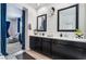 This is a bathroom featuring dual vanities, dark cabinets, and a view into an adjacent main bedroom at 9565 Camelback Creek Dr, Las Vegas, NV 89178