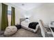 This is a bedroom with neutral walls, gray carpet, a bed, and bean bag chair, and a green curtain at 9565 Camelback Creek Dr, Las Vegas, NV 89178