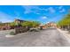 Desert's Edge gated community entrance with lush landscaping and modern home exteriors, under a bright blue sky at 9565 Camelback Creek Dr, Las Vegas, NV 89178