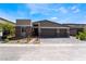 Charming single-story home featuring a three-car garage and stone accents on the facade, set against a clear blue sky at 9565 Camelback Creek Dr, Las Vegas, NV 89178