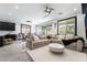 A modern living room with stylish furniture, neutral tones, and natural light from large windows, creating an inviting space at 9565 Camelback Creek Dr, Las Vegas, NV 89178