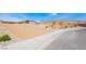 A view of a street and landscaped area, showcasing desert-style landscaping on a sunny day in the community at 9565 Camelback Creek Dr, Las Vegas, NV 89178