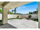 Covered patio and backyard with a concrete patio, lawn, decorative plants and a tall stone wall at , Las Vegas, NV 89135