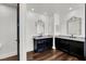 Dual vanity bathroom features a wood floor, marble countertops, decorative mirrors, and black cabinets at , Las Vegas, NV 89135