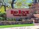 Stone monument sign for Red Rock Country Club with red lettering, decorative plants, and manicured landscaping at , Las Vegas, NV 89135