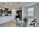 Dining room boasts contemporary lighting, next to open kitchen with stainless steel appliances and sleek countertops at 1004 Huckburn Ave, Henderson, NV 89015