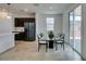 Dining area with tiled floors and glass table, adjacent to a modern kitchen with stainless steel appliances at 1004 Huckburn Ave, Henderson, NV 89015