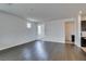 Bright living room featuring hardwood floors, white walls and neutral color scheme throughout home at 1004 Huckburn Ave, Henderson, NV 89015