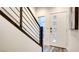Modern entryway with a white door, black metal staircase, and gray wood-style flooring at 1157 Blossom Point St, Las Vegas, NV 89135