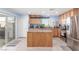 A neutral kitchen, with tile countertops, stainless steel appliances, and a sliding door to the backyard at 11739 Village Arbor St, Las Vegas, NV 89183