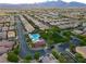 Scenic aerial shot of a suburban neighborhood featuring a community pool and lush green spaces with mountain views at 1181 Blossom Point St, Las Vegas, NV 89135