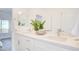 Well-lit bathroom with double sinks, white cabinets, and a decorative plant at 1187 Blossom Point St # 36, Las Vegas, NV 89135