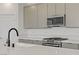 Close up of a kitchen featuring a large sink, stainless steel gas range and hood, and quartz countertops at 12123 Glentana View St, Las Vegas, NV 89138