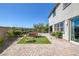 Paver patio with outdoor seating and artificial turf creates a cozy backyard entertaining space at 12311 Middle Creek St, Las Vegas, NV 89138