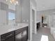 Modern bathroom featuring a large vanity area, walk-in shower and soaking tub with natural light at 12311 Middle Creek St, Las Vegas, NV 89138