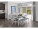 Sunlit dining area with a modern table, bench, and chairs, next to sliding doors to the backyard at 12311 Middle Creek St, Las Vegas, NV 89138