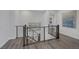 Upstairs hallway with modern railing, neutral walls, and grey wood flooring at 12311 Middle Creek St, Las Vegas, NV 89138