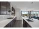 An open kitchen features a gas cooktop, sleek gray cabinets, and an island that flows into a bright dining area at 12311 Middle Creek St, Las Vegas, NV 89138
