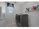 Bright laundry room features modern washer and dryer, shelving, and natural light from a window at 12311 Middle Creek St, Las Vegas, NV 89138