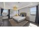 Well-lit main bedroom boasts tray ceilings, stylish chandelier and bedside pendant lights at 12311 Middle Creek St, Las Vegas, NV 89138