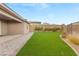 A backyard with artificial grass, brick paving, and privacy walls provides room for relaxation at 12550 Point Sierra St, Las Vegas, NV 89138