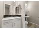 Contemporary bathroom with a white vanity, stylish mirror, and a separate pedestal sink for added convenience at 12550 Point Sierra St, Las Vegas, NV 89138