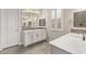 Bathroom featuring dual sinks, white cabinetry, and gray tiled floor at 12550 Point Sierra St, Las Vegas, NV 89138