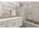 Bathroom featuring dual sinks, shower, white cabinetry, and chrome fixtures at 12550 Point Sierra St, Las Vegas, NV 89138
