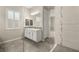Bright bathroom featuring a white vanity with double sinks and a separate shower with decorative tile at 12550 Point Sierra St, Las Vegas, NV 89138