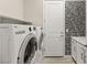 Modern laundry room with front load washer/dryer and decorative tiled shower in the background at 12550 Point Sierra St, Las Vegas, NV 89138
