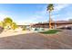 A spacious backyard featuring a pool with spa, palm tree, artificial grass and rock features at 1500 Tumbleweed Dr, Henderson, NV 89002