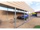 A metal awning covers a parking spot for recreational vehicles on a gravel area in the backyard at 1500 Tumbleweed Dr, Henderson, NV 89002