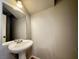 Powder room featuring a pedestal sink, mirror and tile floors at 2105 William Holden Ct, Las Vegas, NV 89142