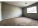 A spacious bedroom with neutral carpeting and a window providing natural light at 2105 William Holden Ct, Las Vegas, NV 89142