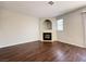 Spacious living room with hardwood floors featuring a tile fireplace, window, and gray painted walls at 2105 William Holden Ct, Las Vegas, NV 89142