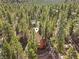 Aerial view of a rustic log cabin nestled among lush trees, showcasing the beauty of the natural surroundings at 2160 Via Vita St, Mount Charleston, NV 89124