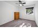 Cozy bedroom with neutral carpet, a ceiling fan, a window with tree views, and a wooden dresser at 2160 Via Vita St, Mount Charleston, NV 89124