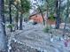 Exterior view of a log cabin home surrounded by trees and a rocky landscape at 2160 Via Vita St, Mount Charleston, NV 89124