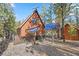 Exterior log cabin home featuring solar panels, woodpile and deck at 2160 Via Vita St, Mount Charleston, NV 89124