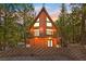 Charming cabin with a-frame design and multiple windows surrounded by lush greenery and offering mountain views at 2160 Via Vita St, Mount Charleston, NV 89124